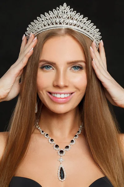 Beautiful woman wearing diamond and sapphire jewelry necklace and crown closeup portrait
