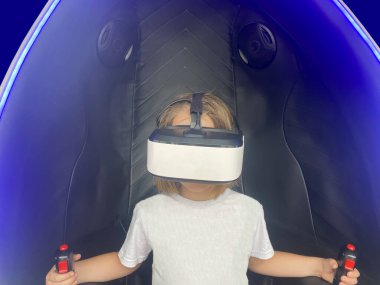 Sanal gerçeklik kabininde çalan gözlüklü esmer kız eğleniyor.