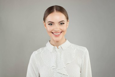 Mutlu gülümseyen kadın beyaz arka planda kameraya bakıyor.