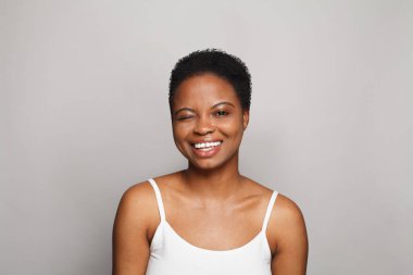 Göz kırpan sağIıklı model kadın koyu tenli ve sevimli gülüşlü yakın plan portresi olan.. 