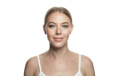 Sağlıklı, taze bir teni ve beyaz arka planda izole edilmiş doğal makyajı olan genç ve güzel bir kadın. Cilt bakımı, yüz bakımı ve kozmetoloji kavramı