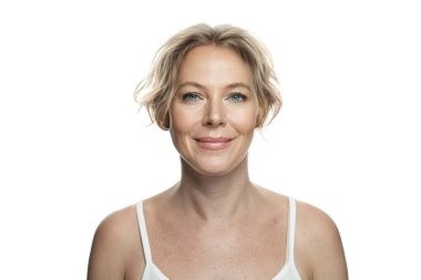 Beyaz arka planda sağlıklı, taze bir teni ve doğal makyajı olan çekici, olgun bir kadın. Cilt bakımı, yüz bakımı ve kozmetoloji kavramı