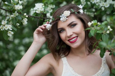 Açık hava esmer kadın portresi. Sağlıklı kadın yeşil çiçekli arka plana karşı