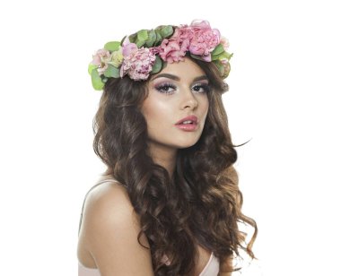 Makyajlı, uzun dalgalı saç stili, sağlıklı cilt ve beyaz arka planda izole edilmiş çiçekler olan hoş, genç esmer bir kadın.