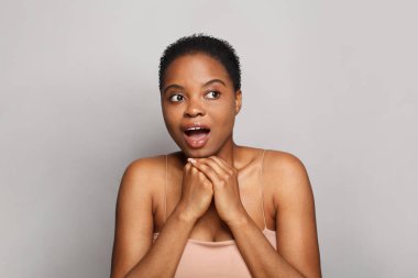 Beyaz arka planda koyu tenli neşeli, sağlıklı bir bayan. Reklamcılık, ürün yerleştirme, ilaç ve tedavi kavramı