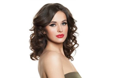 Uzun dalgalı saçlı, makyajlı ve sağlıklı ciltli güzel esmer kadın model beyaz arka planda kameraya bakıyor.