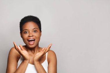 Şaşırmış sağIık modeli, koyu tenli, güzel gülüşlü, yakın plan portresi olan kadın.. 