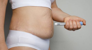 Kendi kendine enjekte etme. İğne kalemli kadın model, yakın plan. İlaç ve tedavi kavramı