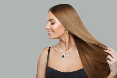 Güzel bir mücevher modeli güzel bir kadın portresi. Esmer kadın profili, uzun düz saçlı ve kolyeli.