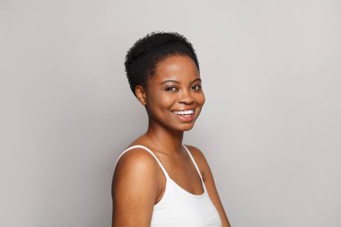 Beyaz arka planda koyu tenli, oldukça sağlıklı bir kadın. Reklamcılık, ürün yerleştirme, ilaç ve tedavi kavramı