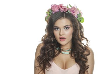 Makyajlı, açık tenli, parlak, uzun dalgalı saç stili ve pembe bahar çiçekli heyecanlı esmer model. Cilt bakımı, saç bakımı, kozmetoloji ve güzellik konsepti