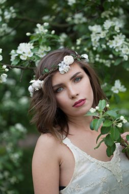 İlkbahar parkında poz veren çekici, sağlıklı bir kadın, yakın plan portresi.