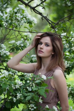 Bahar aylarında esmer kadın model arka planda kalır.