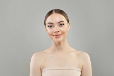 Güzel cildi ve beyaz arka planda sevimli gülüşü olan şık, sağlıklı model bir kadın, stüdyo resmi. Yüz bakımı, cilt bakımı ve kozmetik konsepti