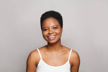 Güzel, sağlıklı bir kadın portresi. Temiz bir ten ve beyaz arka planda güzel bir gülümseme.