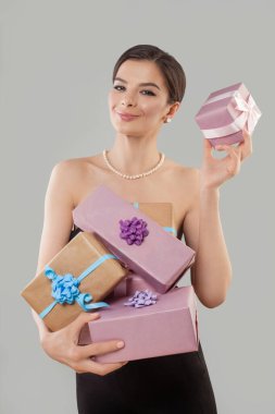 Mutlu, heyecanlı, hediye kutusunu tutan genç bir kadın beyaz stüdyo duvarına poz veriyor. .