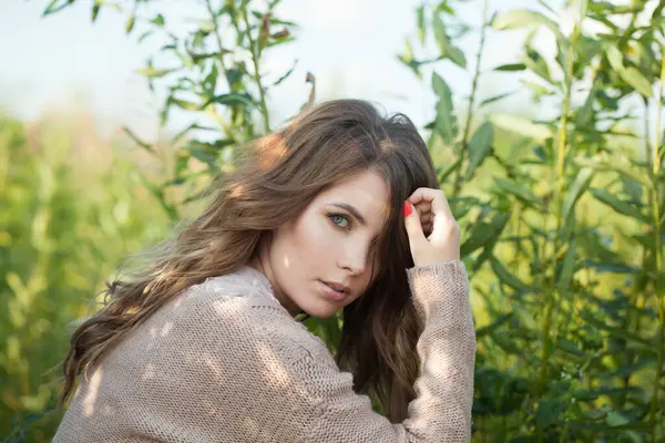 Uzun dalgalı saç stili, doğal makyajlı, açık hava güzelliği portresi olan sevimli, genç model kadın esmer.