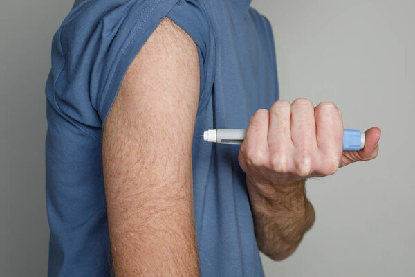 Man injecting insulin in hers arm