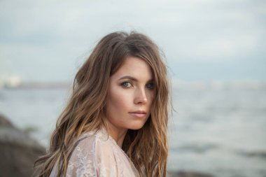 Rüzgarlı kahverengi saçlı çekici, genç bir kadın model.