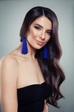 Pürüzsüz Teni, Makyajı ve Mavi Mücevheri olan Güzel Kadın. Gülümseyen küpeli zarif model portresi