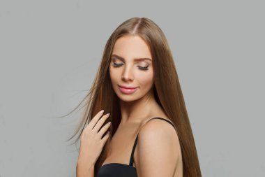 Uzun saçlı ve doğal makyajlı neşeli kadın model esmer beyaz arka planda izole edilmiş.