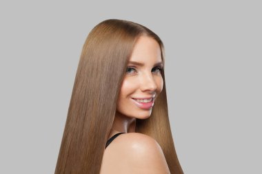 Uzun saçlı ve doğal makyajlı zarif kadın model esmer beyaz arka planda yalnız poz veriyor.