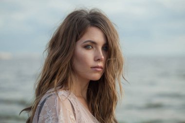 Rüzgarlı kahverengi saçlı, genç ve güzel bir bayan model.