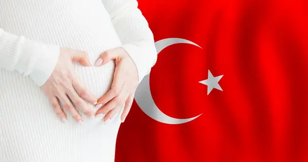 stock image Demographics, pregnancy and love baby in Turkey concept. Pregnant woman making heart against her stomach on Turkish flag background. 