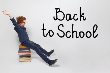 Mutlu çocuk okulu çocuğu beyaz arka planda eğleniyor. Okul konseptine dönelim.