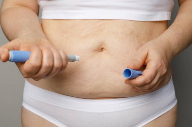 İnsülin iğnesi yapan kadın.