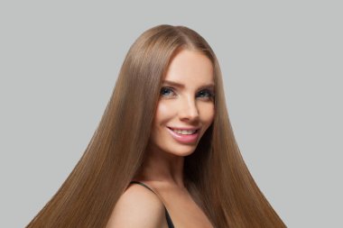 Beyaz arka planda izole edilmiş uzun saçlı ve doğal görünümlü esmer bir kadının moda portresi.