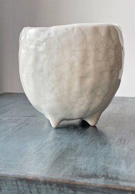 Mavi arka planda beyaz el yapımı seramik saksı. Gargara yapmak için boş tencere