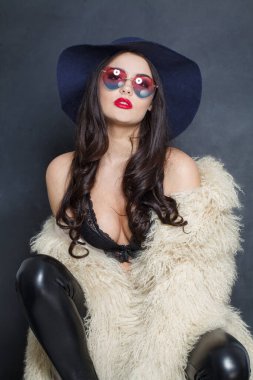 Mavi klasik şapkalı ve beyaz kürklü çekici bir manken kadın. Kapalı alanda poz veriyor. Zarif moda güzellik portresi.