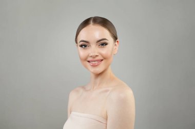 Doğal makyajlı, parlak, temiz ciltli ve mükemmel gülümseyen güzel görünümlü genç bir bayan model. Güzel kadın yüzü