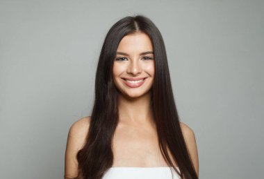 Stüdyo portresi, doğal makyajlı, parlak ciltli ve mükemmel saçlı mutlu genç bir kadın modeli. Güzel kadın yüzü