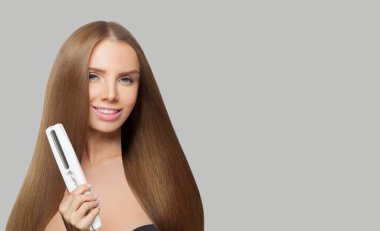 Uzun düz, sağlıklı saç stili olan, beyaz arka planda demiri düzelten gülümseyen bir kadının stüdyo portresi. Güzellik, saç bakımı, saç bakımı ve kozmetik konsepti