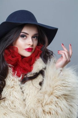 Mavi şapkalı ve beyaz kürklü güzel bir manken kadın. Kapalı alanda poz veriyor. Zarif moda güzellik portresi.