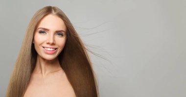 Gülümseyen esmer kadın, Cemera 'ya bakıyor, moda güzellik portresi. Uzun ve sağlıklı saçlı çekici bir kadın model.