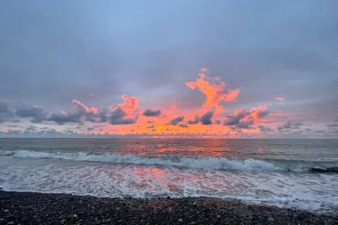 Deniz ve bulutlarla güzel bir gün batımı.