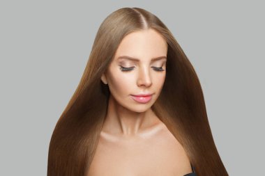 Büyüleyici bir model. Uzun kahverengi saçlı, doğal makyajlı ve sağlıklı ciltli bir kadın.