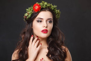 Parlak saçlı, makyajlı ve siyah arka planda bahar çiçeği olan göz kamaştırıcı sağlıklı bir kadın model.