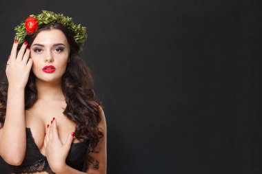 Parlak saçlı, makyajlı ve siyah arka planda bahar çiçeği olan sağlıklı bir kadın model.