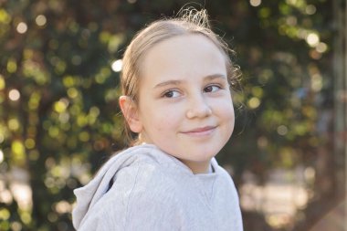Şirin bir çocuk gülümsüyor, açık hava portresi. Mutluluk ve çocukluk kavramı