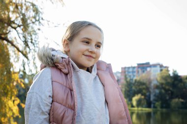 Sevimli çocuk gülümsüyor, açık hava portresi yapıyor. Mutluluk ve çocukluk kavramı