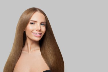 Uzun saçlı ve doğal makyajlı güzel bir kadın model. Beyaz arka planda yalnız poz veriyor.