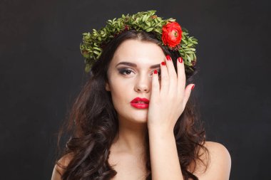 Siyah arka planda parlak saçlı, makyajlı ve bahar çiçekli çekici bir kadın model.