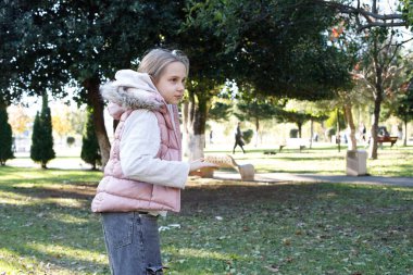 Neşeli mutlu kız çocuğu, güneşli, yeşil bir açık hava ortamında uçan disk çalıyor. Bir çocuğun hayatındaki kaygısız ve neşeli anları temsil ediyor..