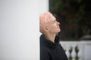 Kısa saçlı, açık havada siyah ceketli, orta yaşlı bir kadın.