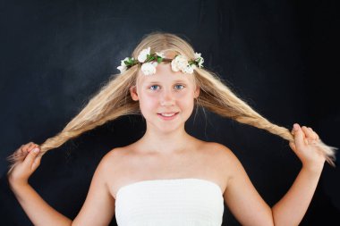 Çiçek desenli güzel bir kız. Siyah arka planda uzun, sağlıklı sarı saçlar. Moda güzellik stüdyosu portresi.