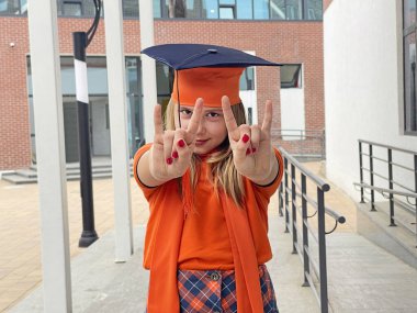 Mezuniyet şapkalı, gülümseyen ve kameraya bakan genç bir kız. Eğitim ve mezuniyet kavramı